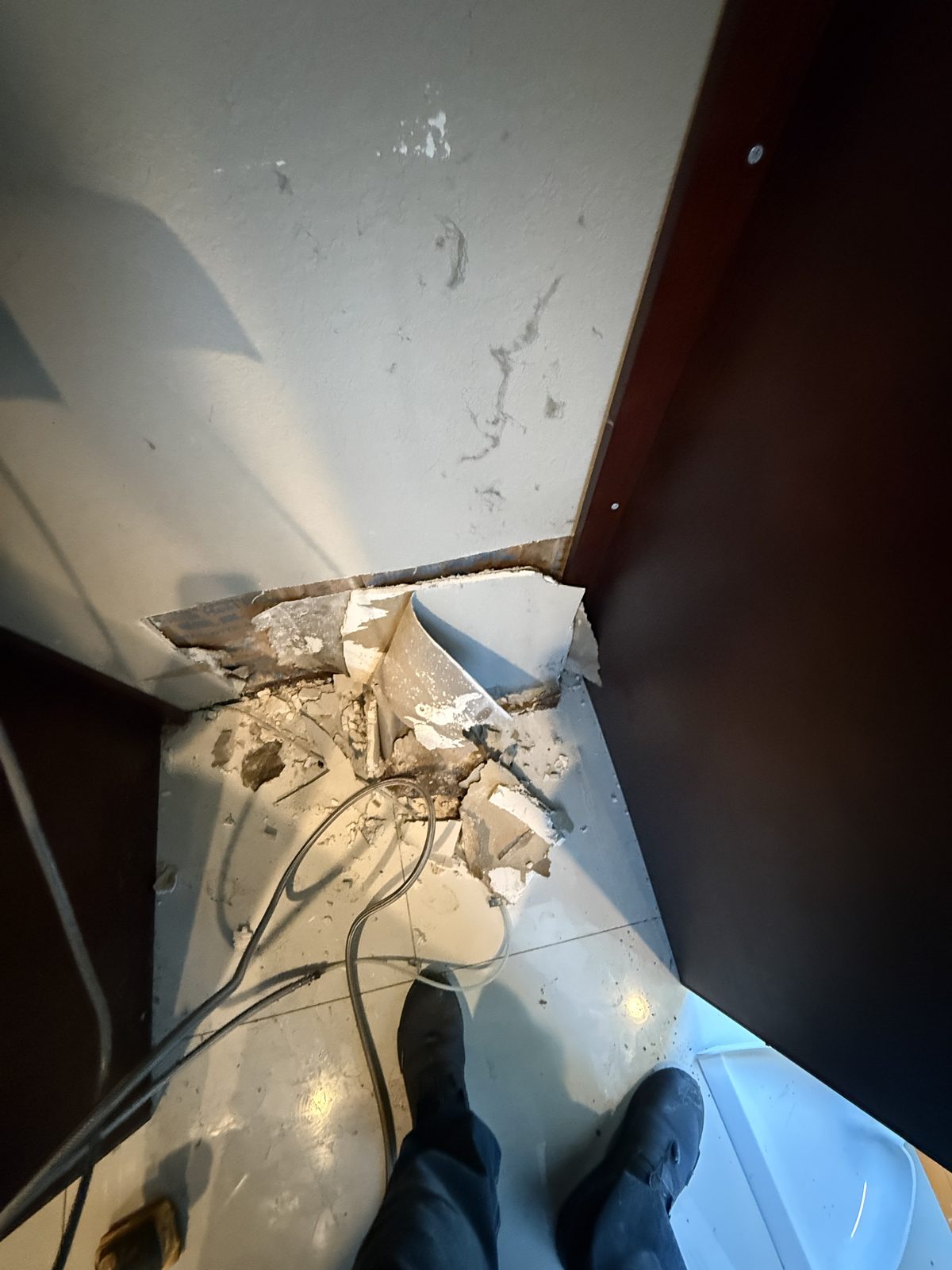 Wall cavity opened behind the kitchen counter revealing damage in a Deerfield Beach home