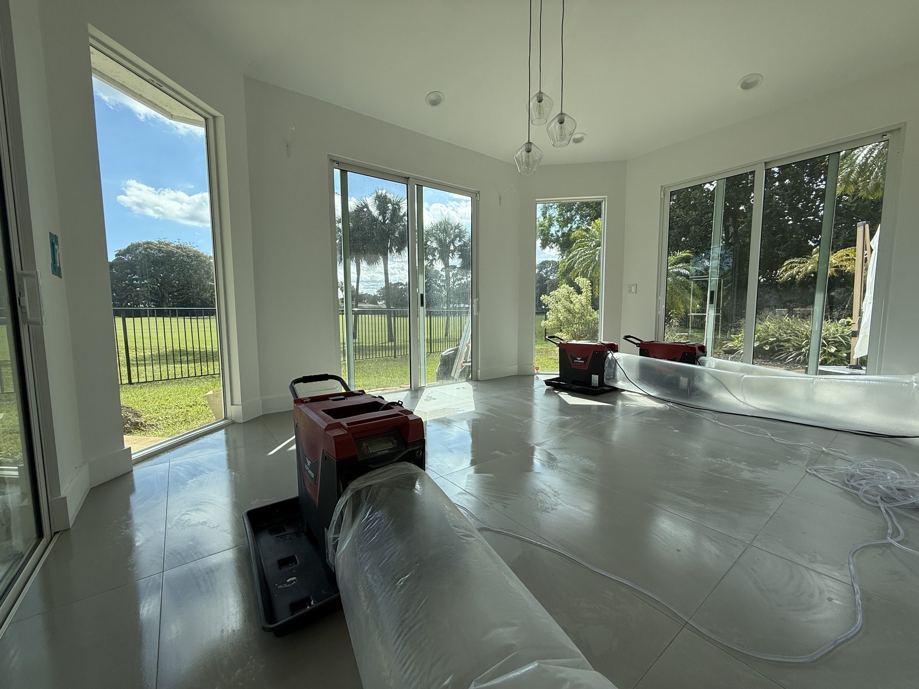 Commercial air movers and lay-flat ducting drying a large room after a water loss in South Florida
